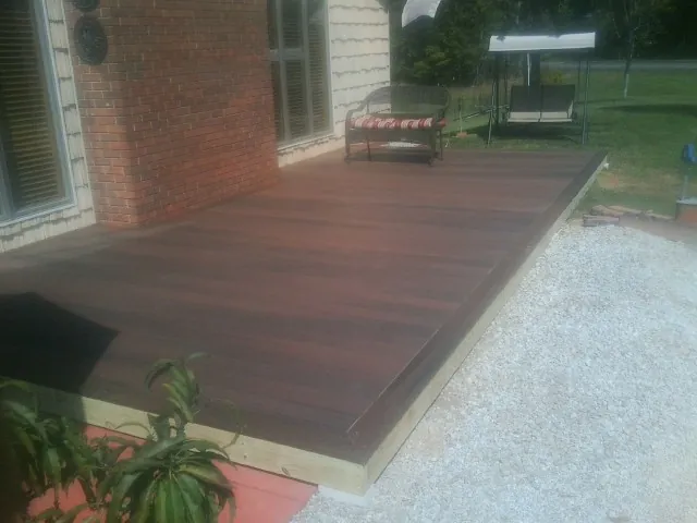 Freshly stained wood deck built against a brick home in Parker